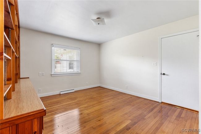 Empty room with baseboard heating, hardwood / wood-style flooring, and baseboards | Image 20