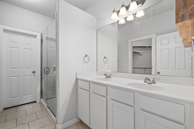 Full bathroom featuring double vanity, a stall shower, and tile patterned flooring | Image 23