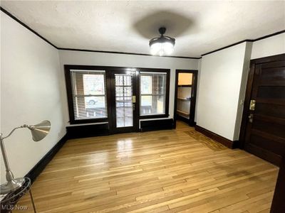 Refinished wood floors, natural woodwork, ceiling fan, door to covered porch overlooking Library Park | Image 3