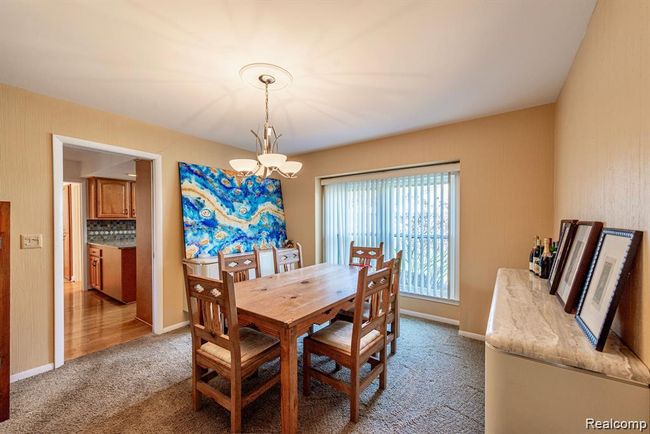 Dining space featuring light colored carpet and a chandelier | Image 14