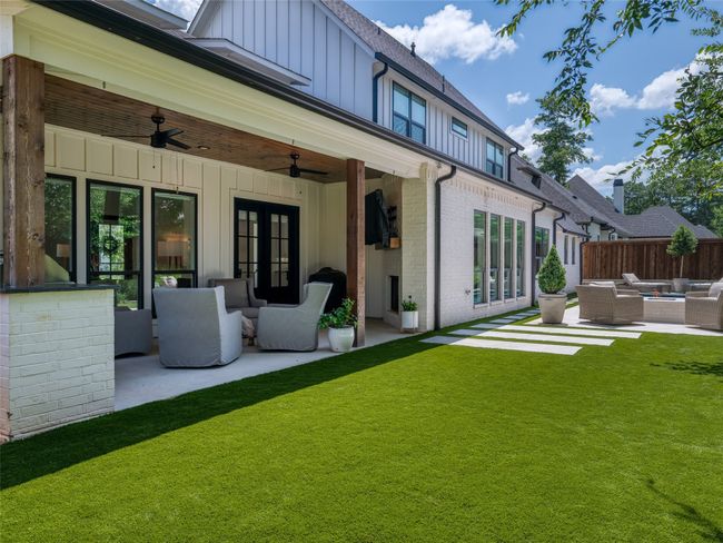 Rear view of house featuring outdoor lounge area, board and batten siding, a patio area, and a ceiling fan | Image 31