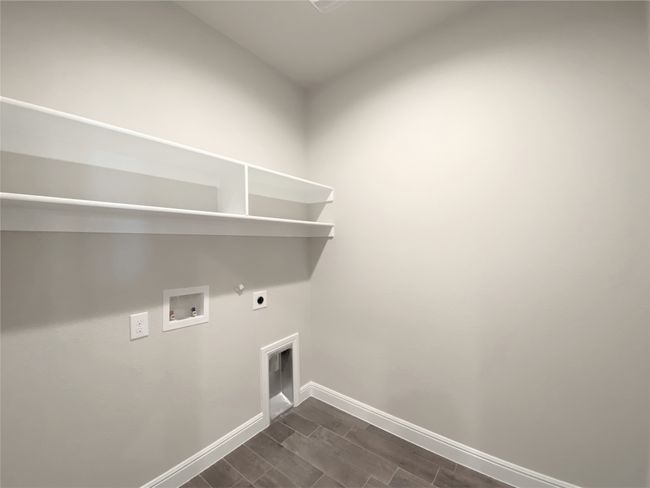 Laundry room featuring electric dryer hookup, hookup for a gas dryer, washer hookup, and wood tiled floors | Image 12