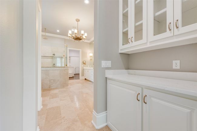Bar featuring hanging light fixtures, recessed lighting, a notable chandelier, and crown molding | Image 23