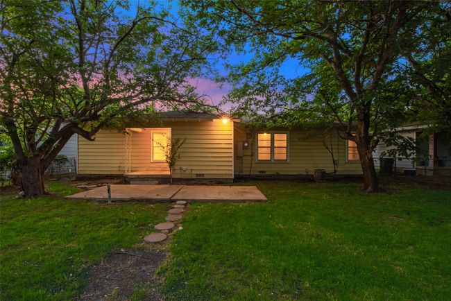 Back of house at dusk with a patio area and a yard | Image 13