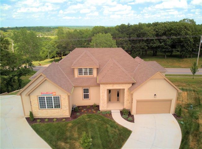 View of front of home featuring concrete driveway, roof with shingles, a garage, a front lawn, and a view of trees | Image 4