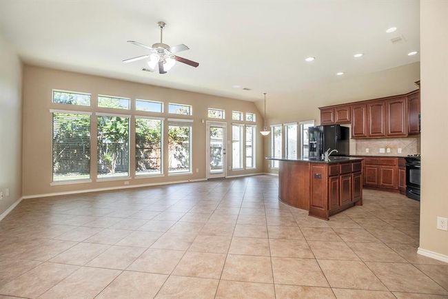 The heart of the home features an open-concept living space with a wall of windows that fills the room with natural light and provides peaceful views of the backyard. | Image 10