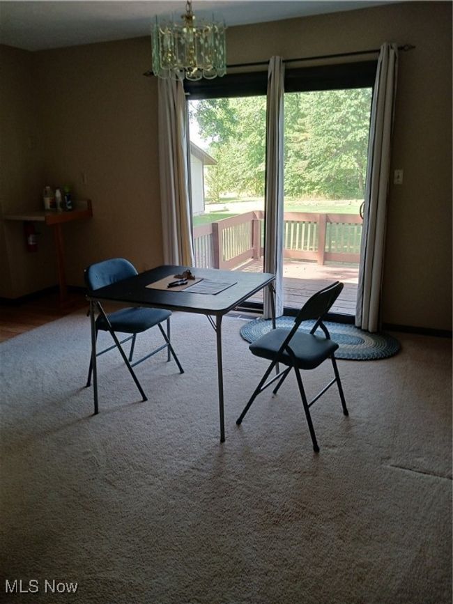 Carpeted dining area with a chandelier | Image 7