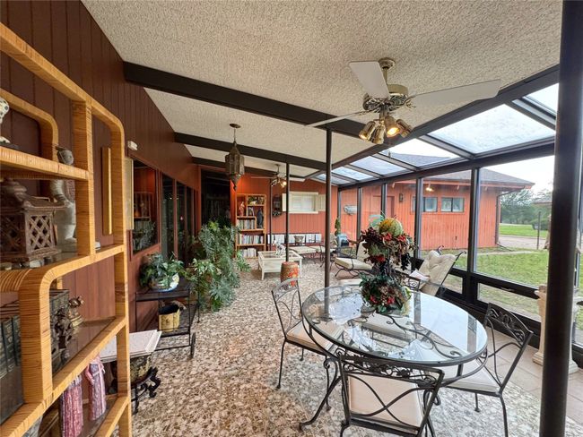 Sunroom / solarium featuring ceiling fan, beamed ceiling, and outdoor dining area | Image 39