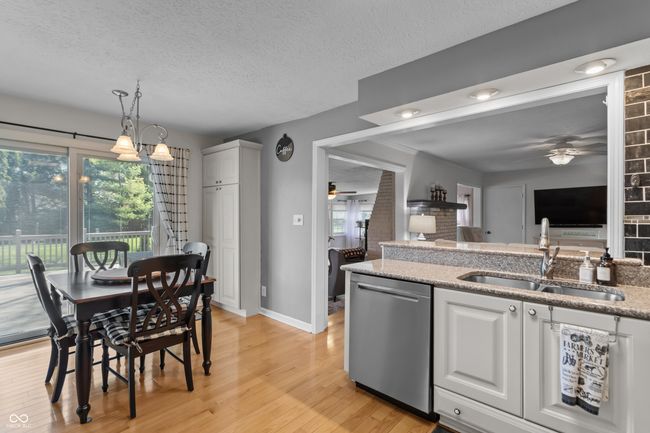 kitchen with light wood-type flooring, a ceiling fan, a sink, and dishwasher | Image 4
