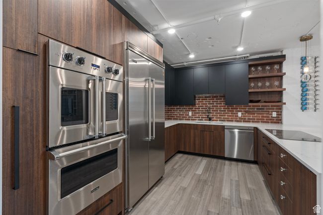 Kitchen with sink, light stone counters, appliances with stainless steel finishes, light hardwood / wood-style floors, and decorative backsplash | Image 10
