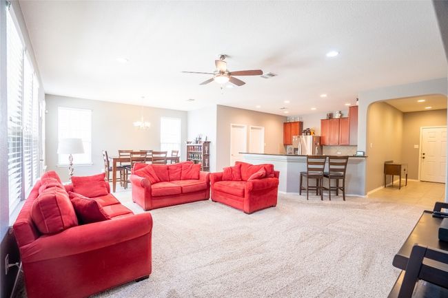 Living area with light carpet, recessed lighting, a ceiling fan, and a chandelier | Image 5