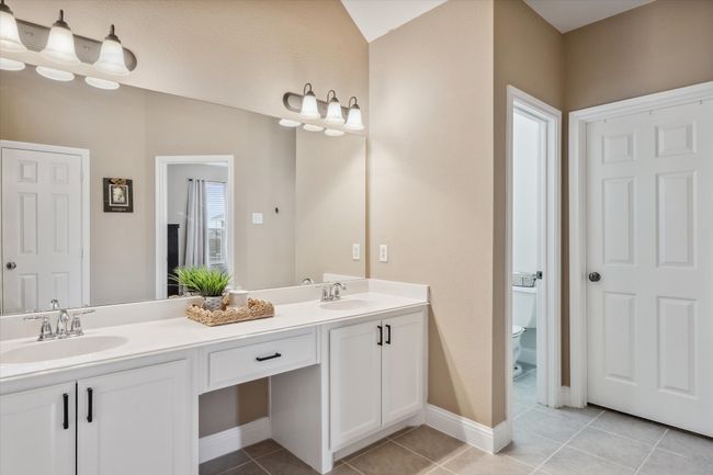 Bathroom with toilet, tile patterned flooring, double vanity, and a sink | Image 17