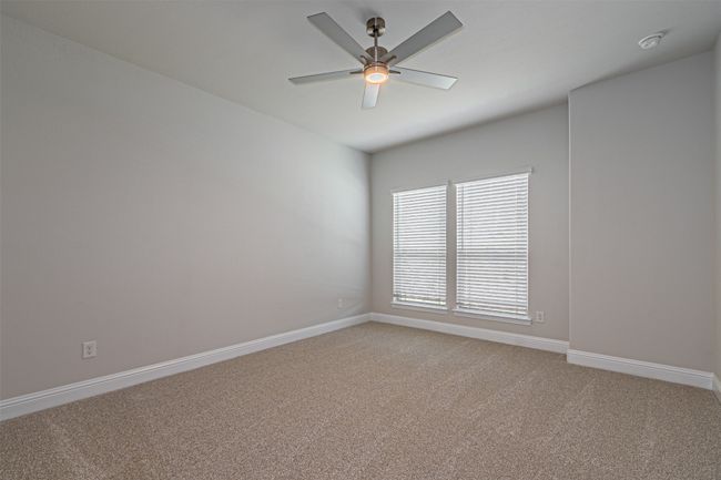 Spare room featuring light carpet, ceiling fan, and a smoke detector | Image 6