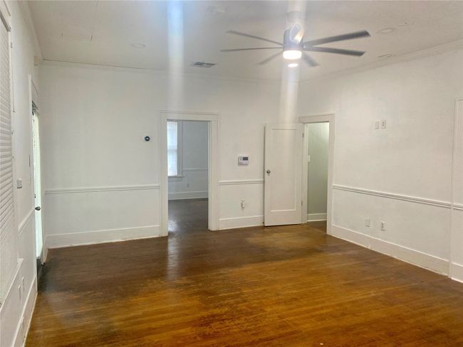 Front room featuring ceiling fan, wood finished floors, and crown molding | Image 6