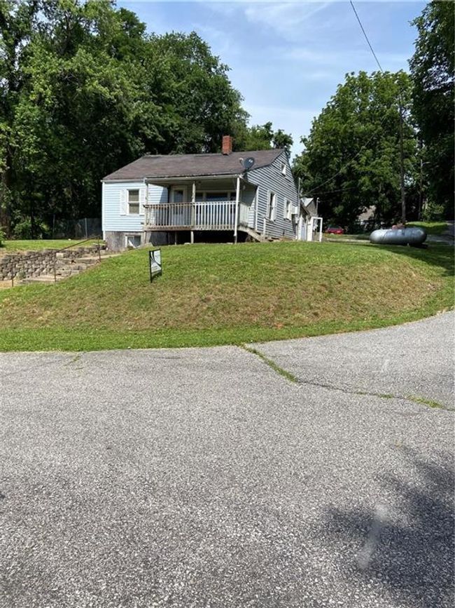 View of front of house featuring a chimney, a wooden deck, and a front yard | Image 16