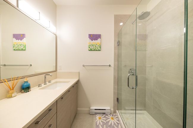 Bathroom with baseboard heating, a stall shower, vanity, baseboards, and tile patterned floors | Image 16