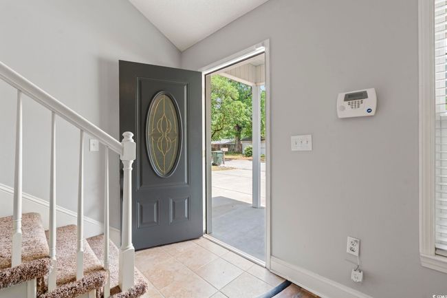 Entrance foyer featuring stairway, vaulted ceiling, light tile patterned floors, and baseboards | Image 35