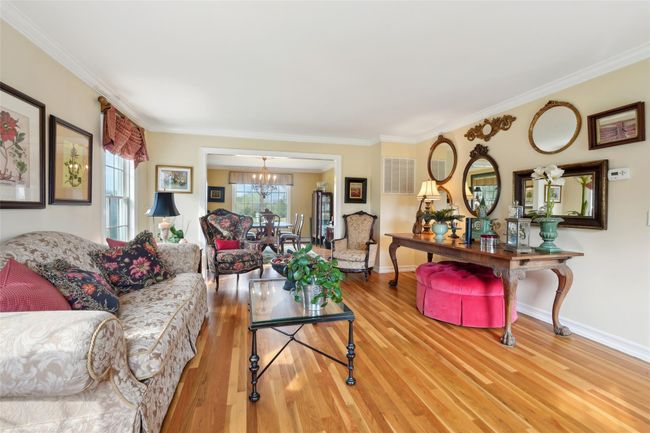 Living area with wood finished floors, a fireplace, ceiling fan, and high vaulted ceiling | Image 11