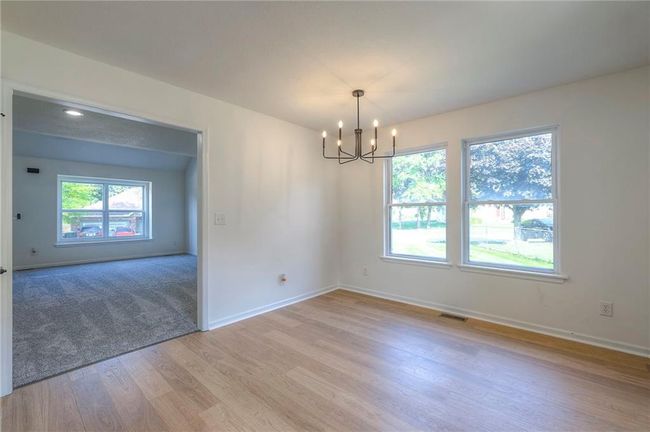Unfurnished room featuring a chandelier and light wood-style flooring | Image 9