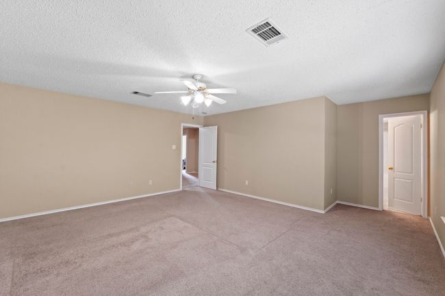 Empty room with a ceiling fan, carpet, baseboards, and a textured ceiling | Image 21