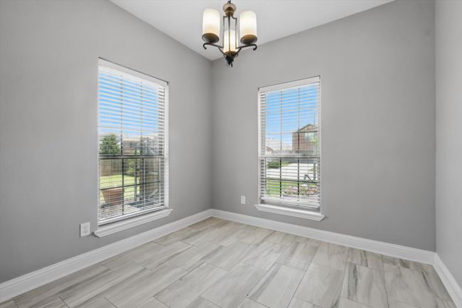 Empty room with a chandelier and baseboards | Image 10