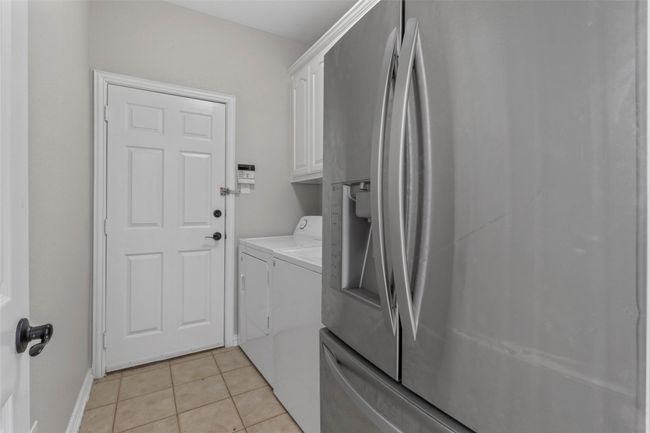 Laundry room with separate washer and dryer, cabinet space, and light tile patterned floors | Image 20