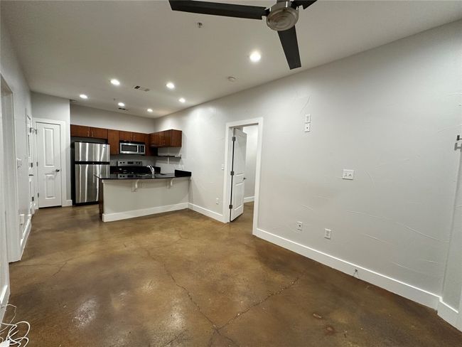 Living room leading to the kitchen with breakfast/dining bar. | Image 4