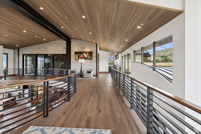 Hallway with vaulted ceiling, wood ceiling, wood finished floors, an upstairs landing, and recessed lighting | Image 101