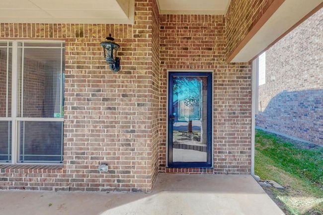 View of exterior entry featuring brick siding | Image 5