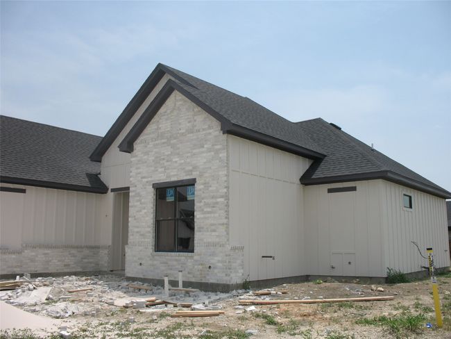 View of side of home featuring brick siding, a shingled roof, and board and batten siding | Image 6