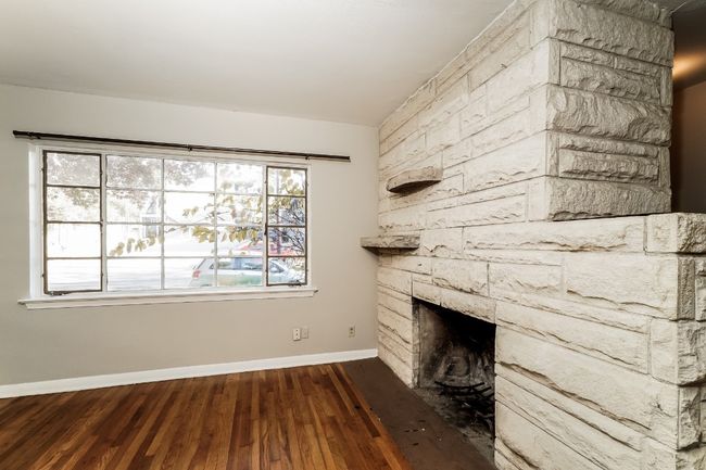 Unfurnished living room with wood finished floors and a fireplace | Image 9