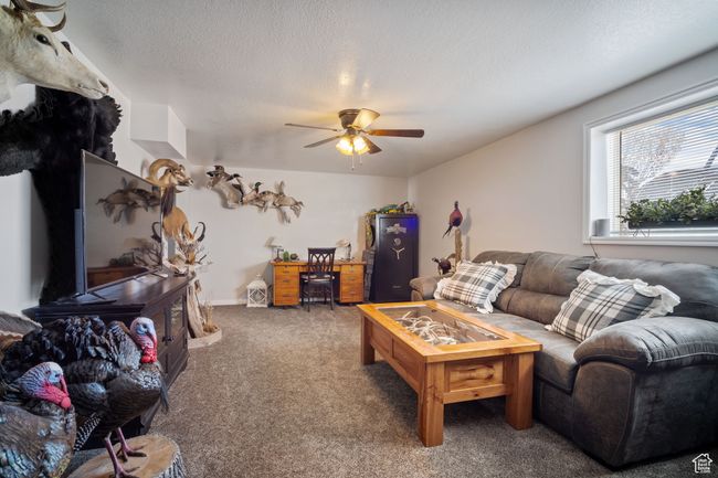 Carpeted living room featuring a textured ceiling and a ceiling fan | Image 13