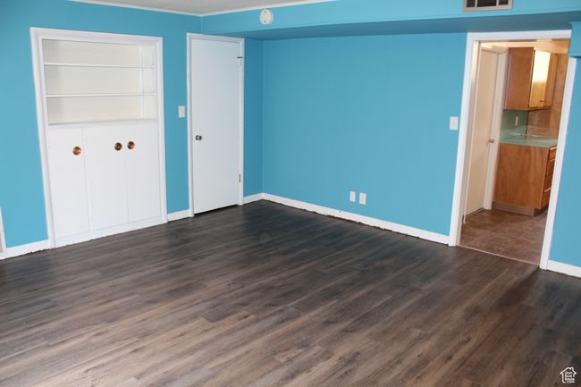 Unfurnished bedroom featuring dark wood-style floors and a closet | Image 15