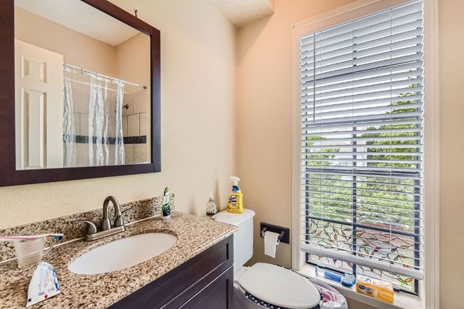 Bathroom featuring a shower with shower curtain, toilet, and vanity | Image 17