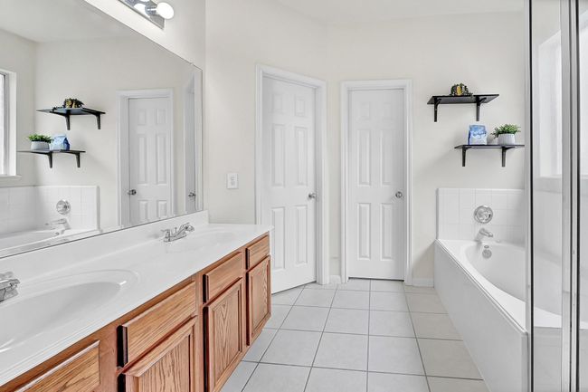 The primary bathroom features a double vanity, large mirror, and shelving for decor or storage. | Image 17