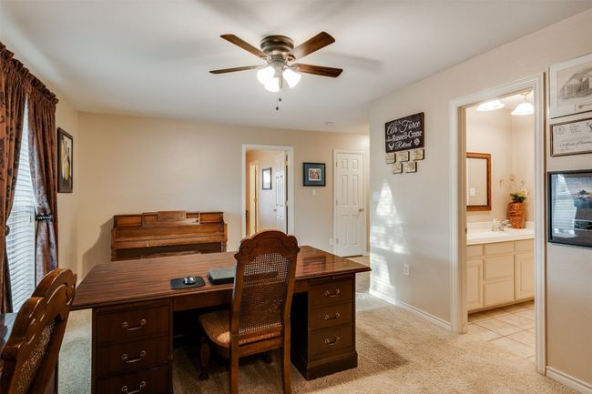Office area with light carpet, a ceiling fan, and baseboards | Image 25