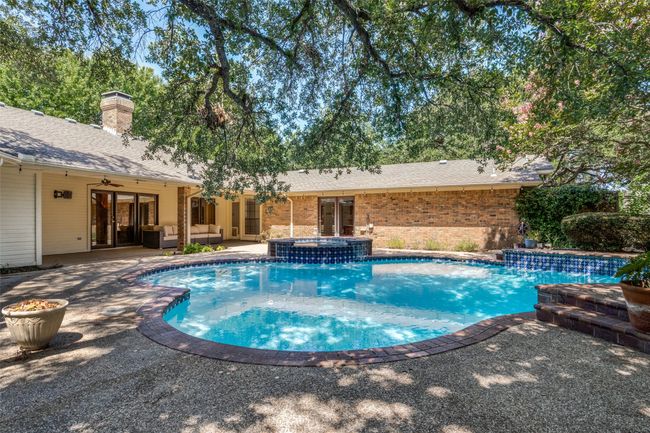 View of pool featuring a patio, a pool with connected hot tub, outdoor lounge area, french doors, and ceiling fan | Image 25