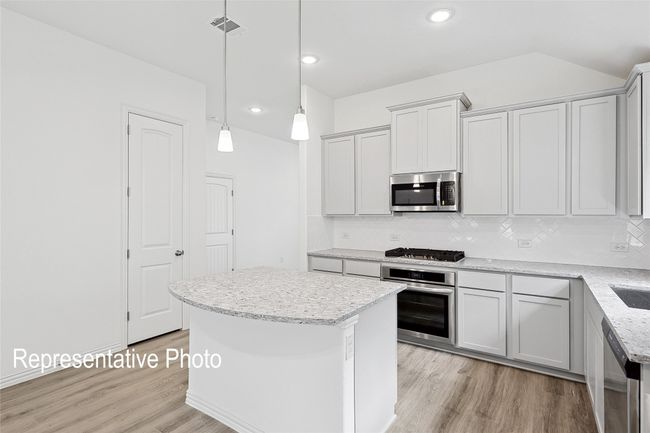Kitchen with backsplash, visible vents, light wood-style floors, and appliances with stainless steel finishes | Image 4