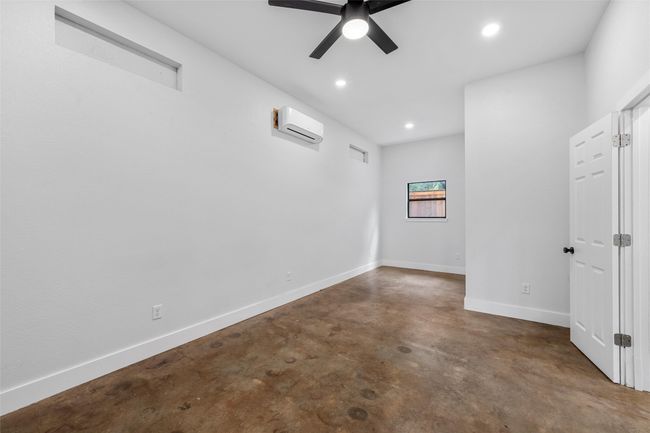 Empty room with concrete floors, recessed lighting, baseboards, a ceiling fan, and an AC wall unit | Image 34