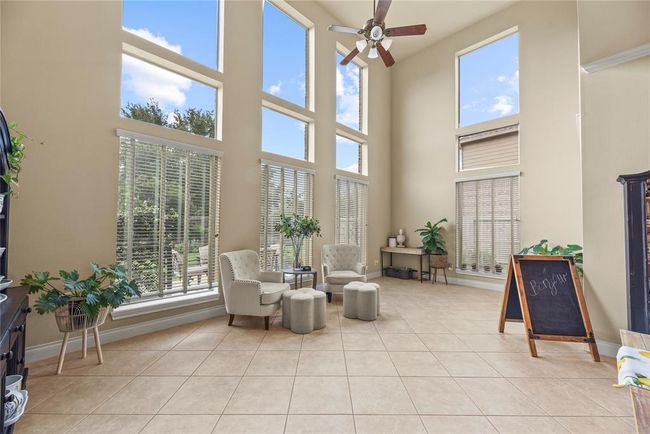 Morning sunshine permeates the two story Sun Room and offers a glimpse of the wel manicured backyard. | Image 12