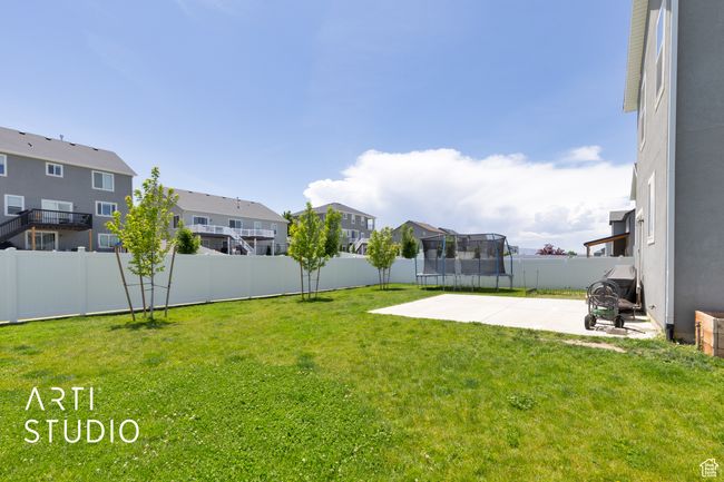 View of yard with a trampoline, a residential view, and a patio | Image 32