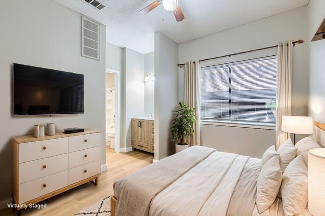 Bedroom featuring ceiling fan, visible vents, light wood-style floors, and ensuite bath | Image 9