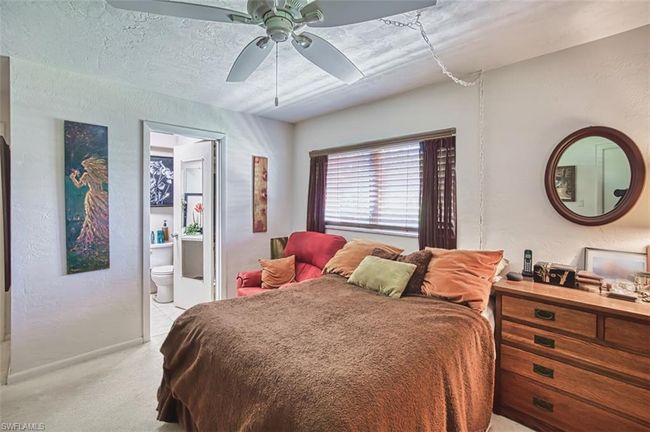 Bedroom with light colored carpet, connected bathroom, and ceiling fan | Image 23