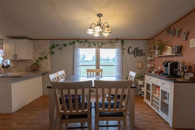 Dining space with a notable chandelier, ornamental molding, and hardwood / wood-style flooring | Image 16