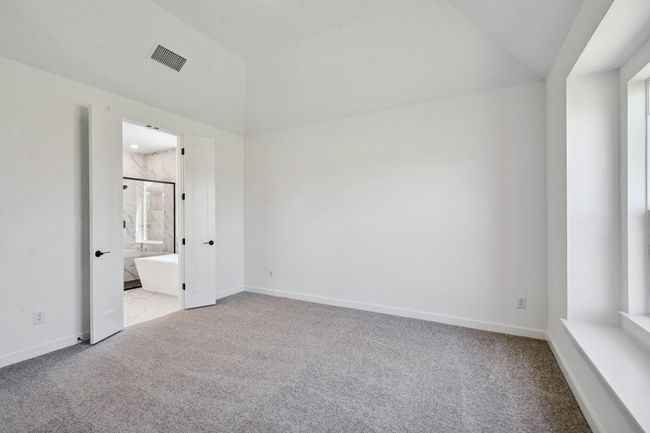 Unfurnished bedroom with light carpet, lofted ceiling, and ensuite bathroom | Image 11