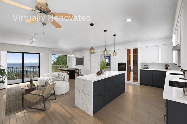 Kitchen featuring open floor plan, a center island, black oven, and dark cabinets | Image 21