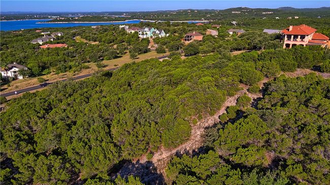 View of lot - Lime Creek Road at southwestern boundary; red roof neighbor house on adjoining lot at northwest side. Image shows flatter building area at upper end of lot | Image 9