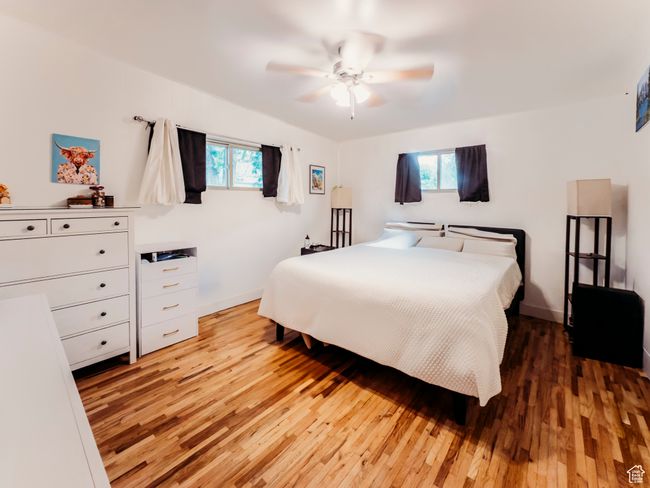Bedroom featuring light wood-style flooring, ceiling fan, and baseboards | Image 10