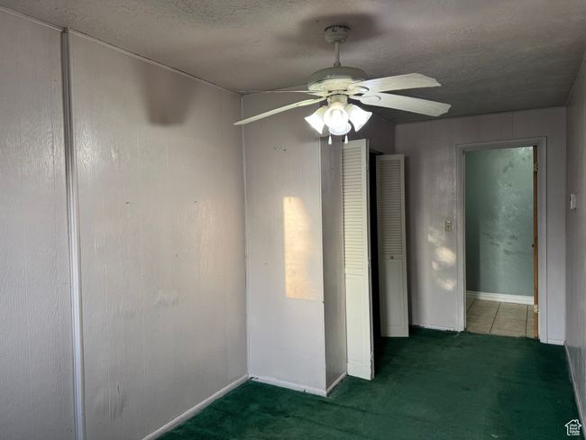 Spare room featuring a ceiling fan, a textured ceiling, carpet floors, and baseboards | Image 16