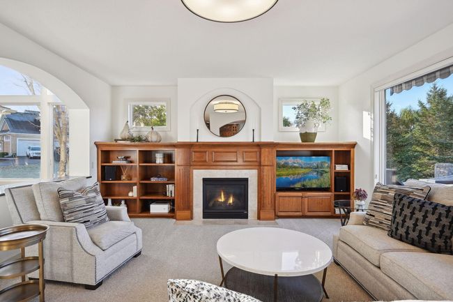 Built-ins surround a gas fireplace and are enhanced by the windows bathing the space with natural light. | Image 15